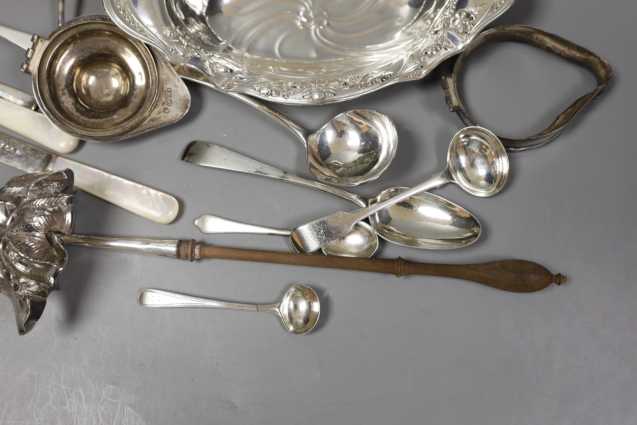 An Edwardian repousse silver oval dish, Birmingham, 1904, 22.8cm, a small quantity of assorted silver flatware including 18th and 19th century pairs of sugar nips, an 18th century silver toddy ladle, white metal cream ju